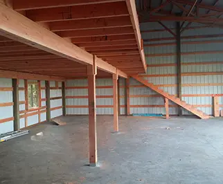 Amish Pole Barn Construction in Carney's Point, NJ - Rossbrook Construction while the barn is being built. Wooden structural frames are seen.