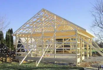 Amish Pole Barn Construction in Elmer, NJ - Rossbrook Construction while the barn is being built. Wooden structural frames are seen.